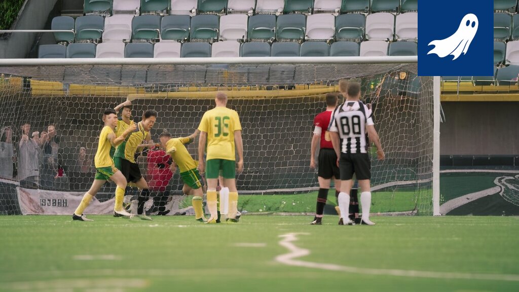 Robottipoliisi valvoo Ilveksen jalkapallo-ottelua Tammelan stadionilla, satiirinen kuva.