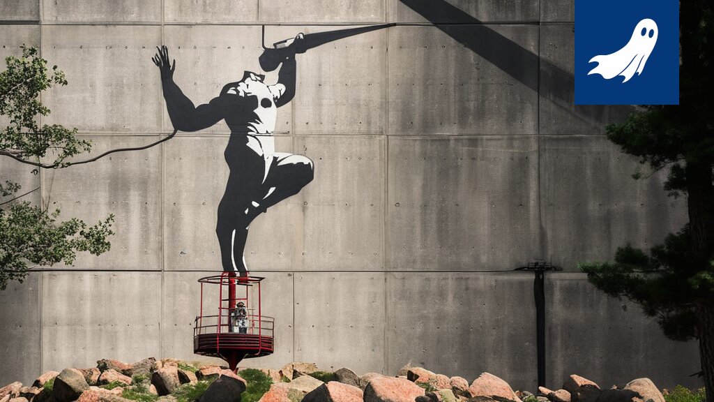 Turun kaupungin seinässä näkyy tekoälyn luoma, Banksy-tyylinen graffitimaalaus, jonka yhteydessä on NFT-sertifioinnin tunnus.